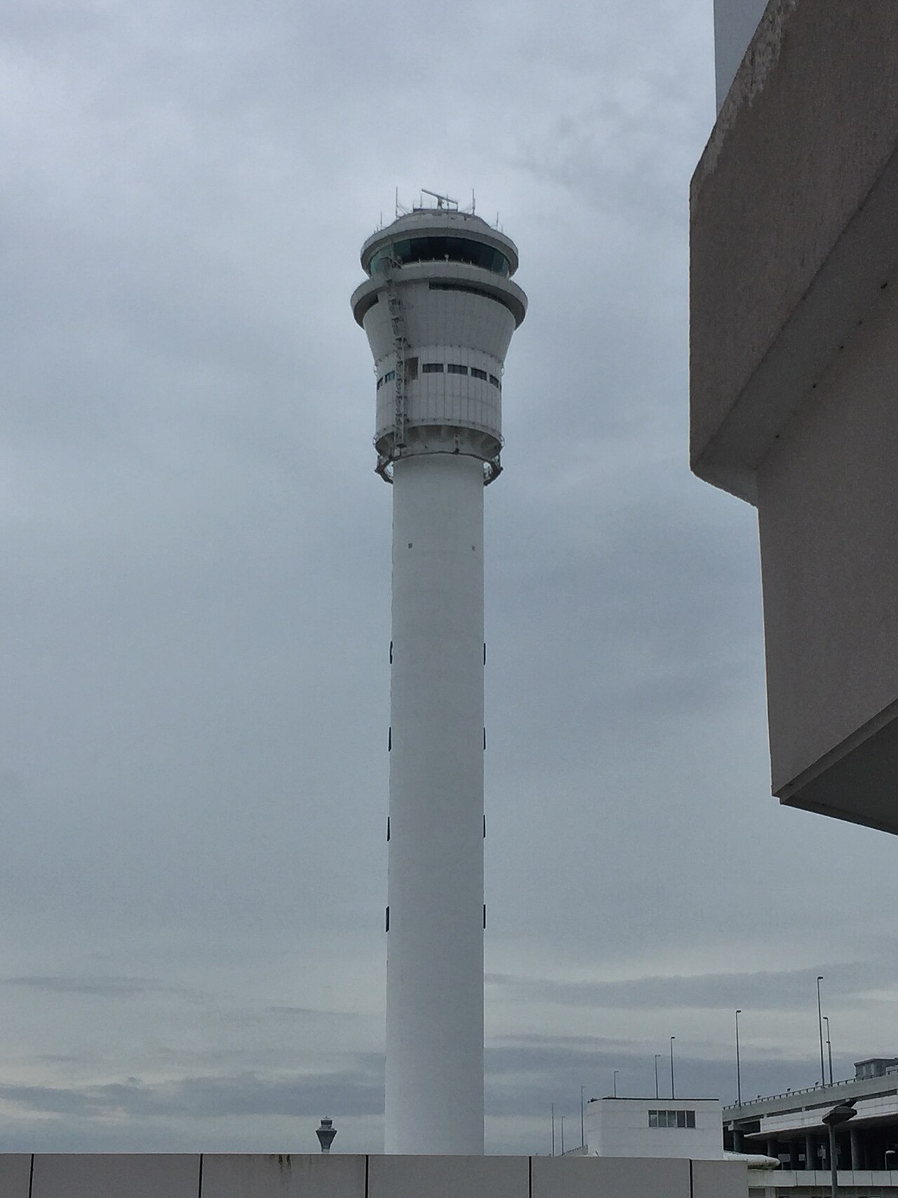 Air traffic control tower standing against an overcast sky